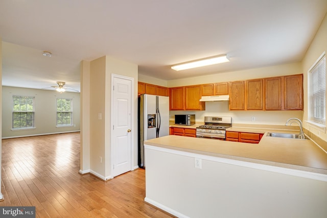 6187 Les Dorson Ln, Alexandria, VA 22315 - kitchen featuring appliances with stainless steel finishes, light countertops, a peninsula, under cabinet range hood, and light wood finished floors