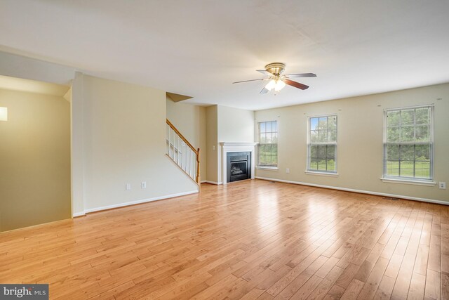 6187 Les Dorson Ln, Alexandria, VA 22315 - unfurnished living room with a ceiling fan, light wood-style floors, stairway, and a fireplace