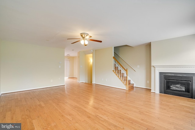 6187 Les Dorson Ln, Alexandria, VA 22315 - unfurnished living room with a ceiling fan, stairs, light wood-type flooring, and a fireplace