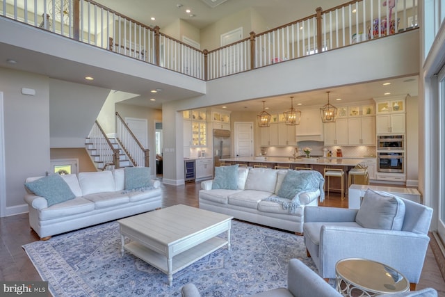 22261 Waterview Rd, Lewes, DE 19958 - living room with a high ceiling, wine cooler, stairway, dark wood-type flooring, and recessed lighting