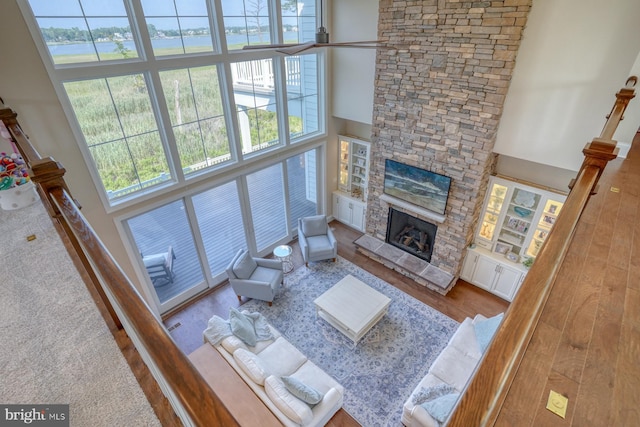 22261 Waterview Rd, Lewes, DE 19958 - living area featuring a high ceiling, a fireplace, wood finished floors, and a water view