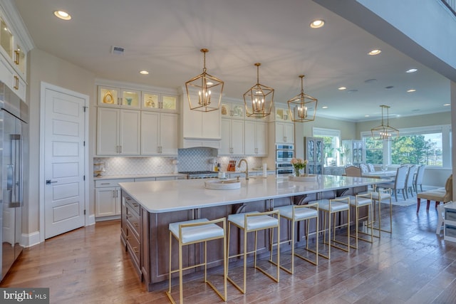 22261 Waterview Rd, Lewes, DE 19958 - kitchen with wood finished floors, white cabinetry, a spacious island, recessed lighting, and ornamental molding