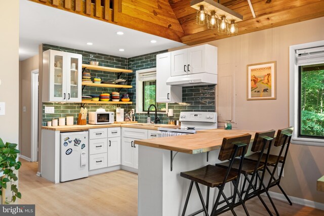 877 Shangri La Rd, Bentonville, VA 22610 - kitchen with wood counters, white appliances, tasteful backsplash, a kitchen breakfast bar, and under cabinet range hood