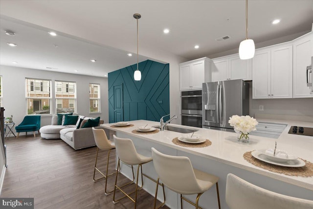 10544 Sally Ride Ln, Lanham, MD 20706 - kitchen featuring appliances with stainless steel finishes, open floor plan, white cabinets, dark wood-style floors, and recessed lighting