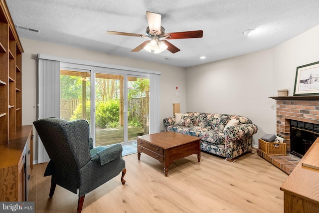 18275 Rolling Meadow Way, Olney, MD 20832 - living area featuring light wood-style flooring, a ceiling fan, a fireplace, and a textured ceiling