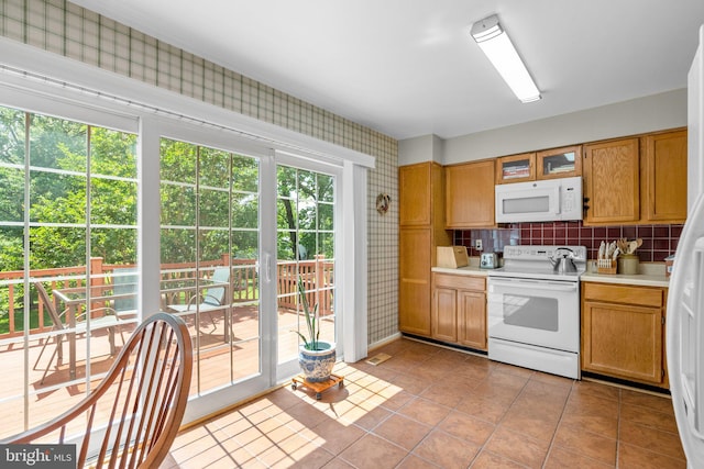 18275 Rolling Meadow Way, Olney, MD 20832 - kitchen with white appliances, wallpapered walls, light countertops, light tile patterned floors, and decorative backsplash