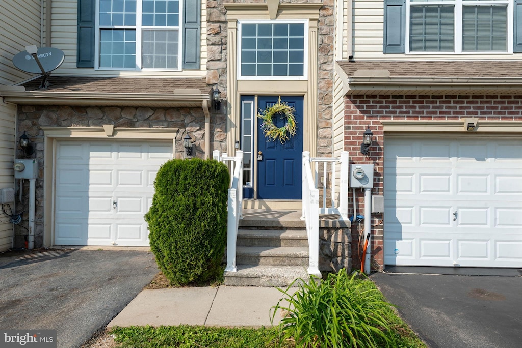 325 Cape Climb, York, PA 17408 - view of exterior entry featuring an attached garage, asphalt driveway, roof with shingles, and brick siding