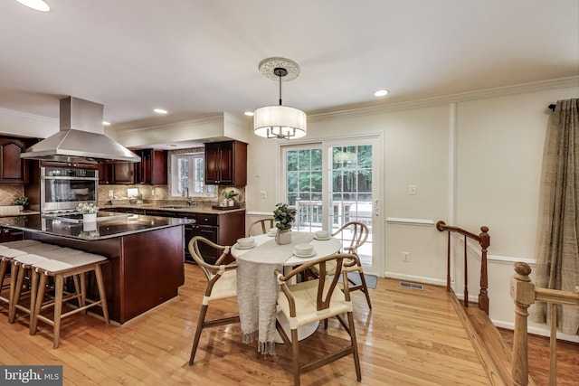 6536 Little Ox Rd, Fairfax Station, VA 22039 - kitchen featuring island range hood, oven, backsplash, ornamental molding, and light wood-style floors