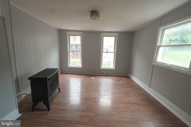 703 Baker St, Cumberland, MD 21502 - unfurnished room with wood finished floors, a wood stove, and wood walls