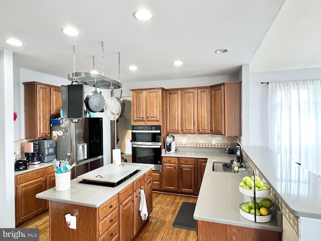 16331 Eagle Flight Cir, Woodbridge, VA 22191 - kitchen with double oven, a kitchen island, light wood finished floors, light countertops, and recessed lighting