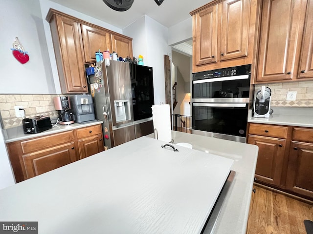16331 Eagle Flight Cir, Woodbridge, VA 22191 - kitchen with stainless steel refrigerator with ice dispenser, double oven, backsplash, and light countertops
