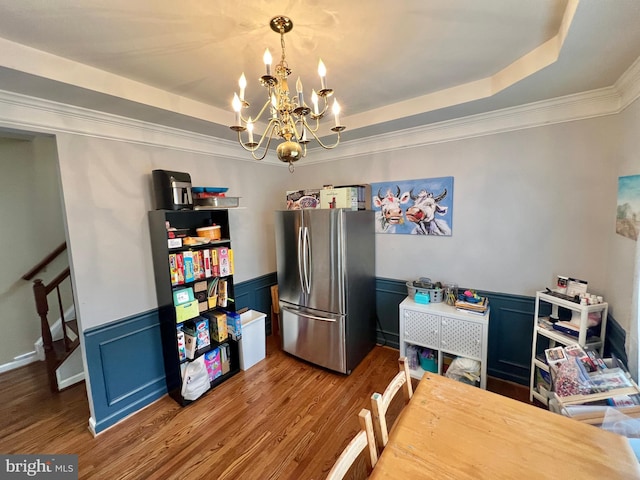 16331 Eagle Flight Cir, Woodbridge, VA 22191 - dining room featuring a raised ceiling, a chandelier, wood finished floors, a wainscoted wall, and crown molding