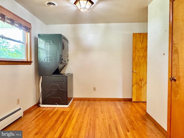 13709 Fir Tree Ln, Cresaptown, MD 21502 - unfurnished room with stacked washer / dryer, baseboard heating, and wood finished floors