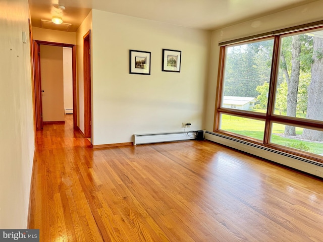 13709 Fir Tree Ln, Cresaptown, MD 21502 - empty room with a baseboard heating unit, light wood-style floors, and plenty of natural light