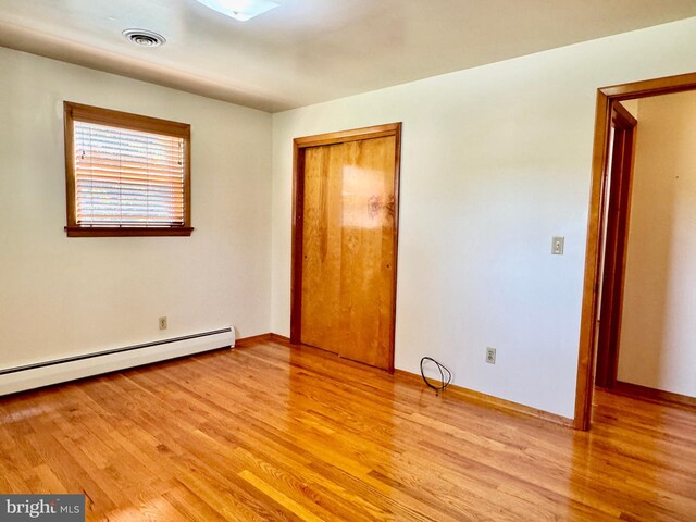 13709 Fir Tree Ln, Cresaptown, MD 21502 - unfurnished bedroom with a baseboard radiator, light wood-type flooring, and a closet