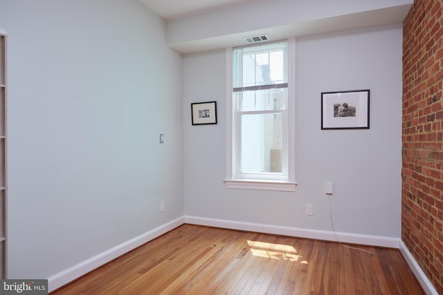 3238 P St NW, Washington, DC 20007 - empty room featuring hardwood / wood-style flooring and brick wall