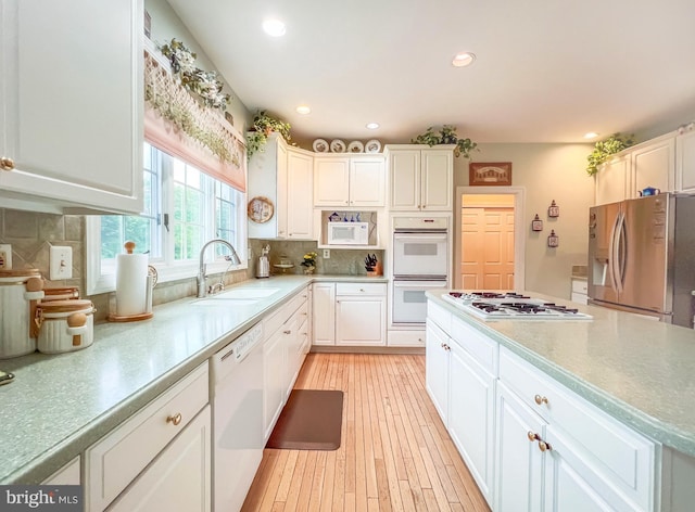 19 Pheasant Run Rd, New Hope, PA 18938 - kitchen with white appliances, white cabinets, backsplash, light wood-type flooring, and light countertops