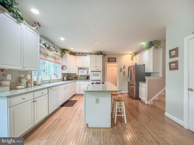 19 Pheasant Run Rd, New Hope, PA 18938 - kitchen with white appliances, light wood-style floors, white cabinets, a kitchen island, and recessed lighting