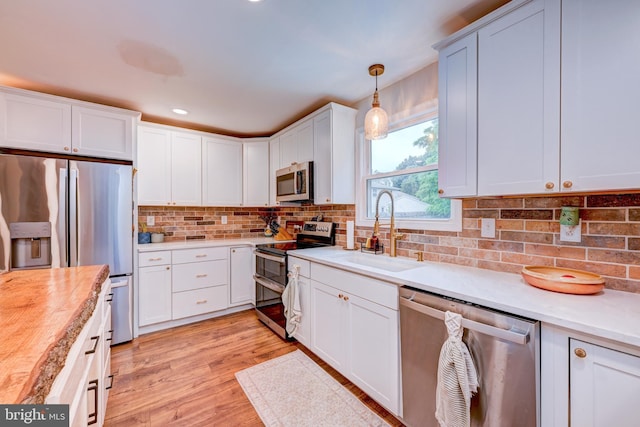 215 Murray Dr, Doylestown, PA 18901 - kitchen featuring stainless steel appliances, light countertops, backsplash, light wood-type flooring, and white cabinets