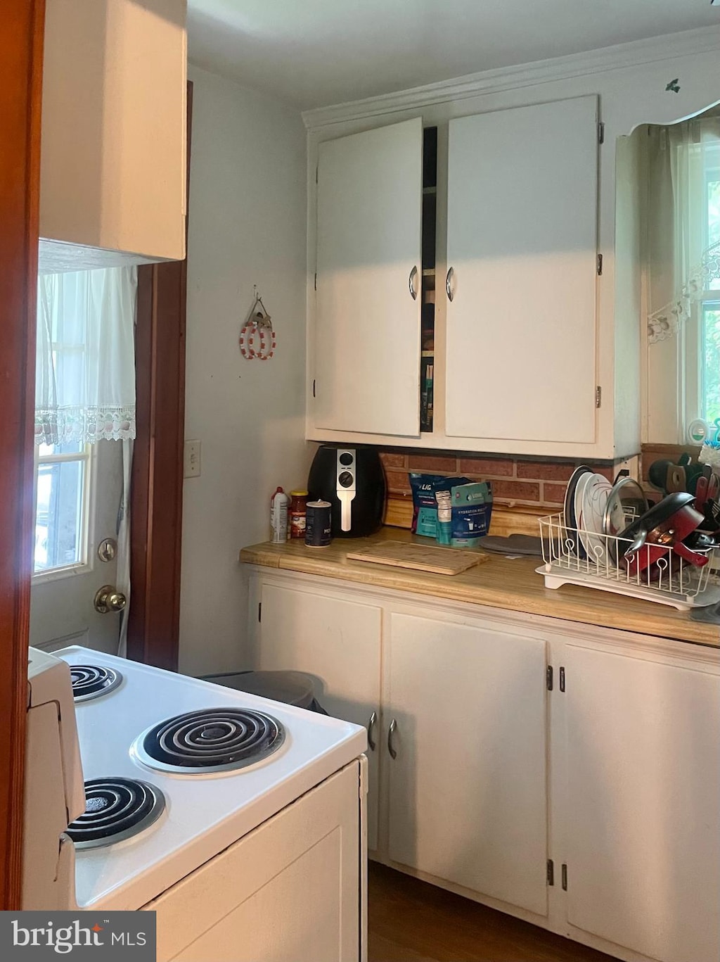 531 Winifred Rd, Cumberland, MD 21502 - kitchen with electric range, white cabinetry, light countertops, and tasteful backsplash