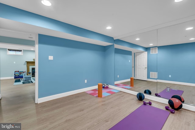 810 Broken Twig Ct, Odenton, MD 21113 - exercise area with wood finished floors, a glass covered fireplace, and recessed lighting