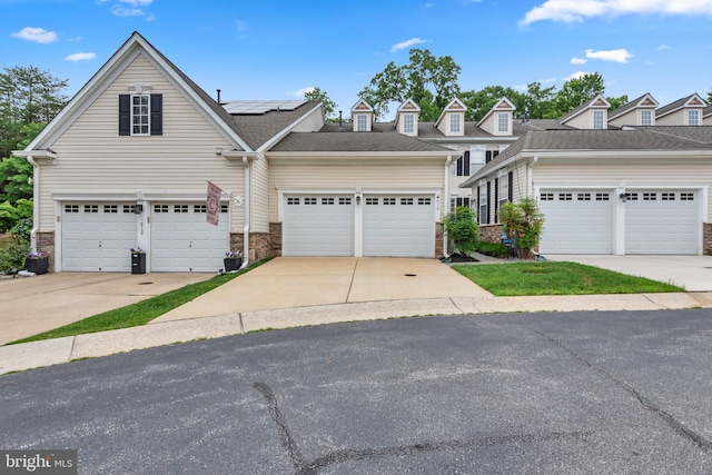 810 Broken Twig Ct, Odenton, MD 21113 - view of front of home featuring roof mounted solar panels, stone siding, and a garage