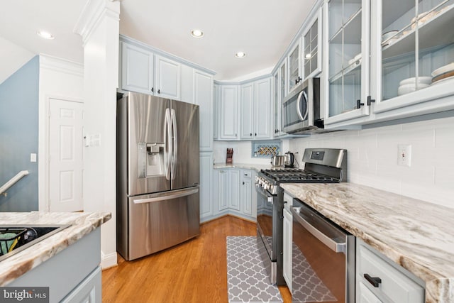2009 Magarity Ct, Falls Church, VA 22043 - kitchen featuring appliances with stainless steel finishes, decorative backsplash, light wood-style flooring, recessed lighting, and light stone countertops