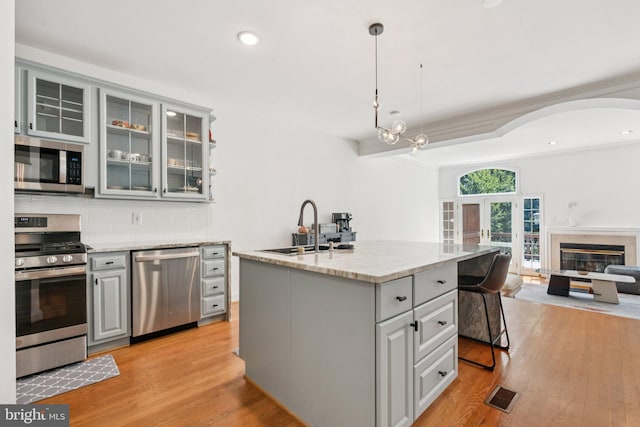2009 Magarity Ct, Falls Church, VA 22043 - kitchen featuring appliances with stainless steel finishes, gray cabinets, open floor plan, tasteful backsplash, and light wood-style flooring