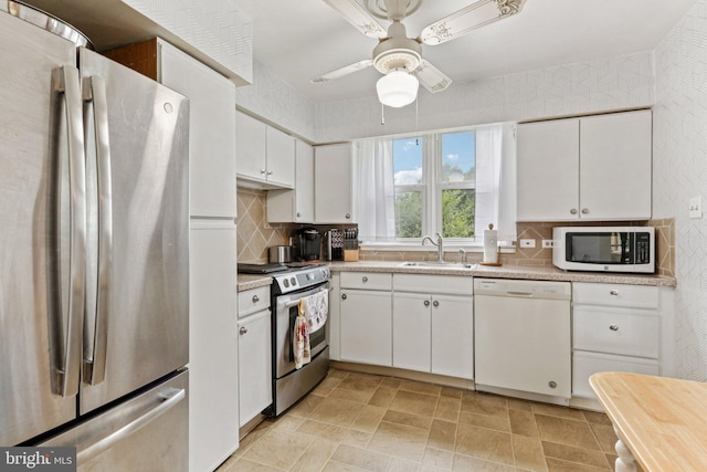 694 Davisville Rd, Warminster, PA 18974 - kitchen with stainless steel appliances, backsplash, white cabinetry, and light countertops