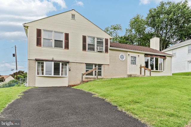 694 Davisville Rd, Warminster, PA 18974 - split level home with a chimney, a front yard, brick siding, asphalt driveway, and cooling unit