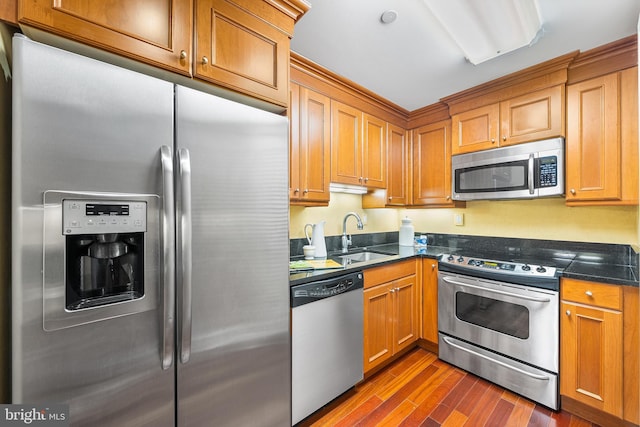 1701 Locust St Unit 2015, Philadelphia, PA 19103 - kitchen with stainless steel appliances, dark wood-style floors, and brown cabinetry