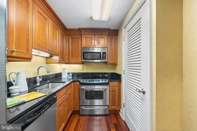 1701 Locust St Unit 2015, Philadelphia, PA 19103 - kitchen with stainless steel appliances, dark wood finished floors, brown cabinetry, and dark stone counters