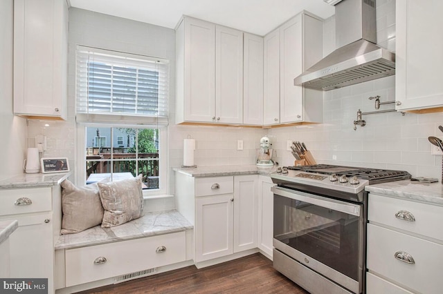 628 Talon Ct, Arnold, MD 21012 - kitchen featuring stainless steel gas stove, wall chimney exhaust hood, white cabinetry, tasteful backsplash, and dark wood finished floors