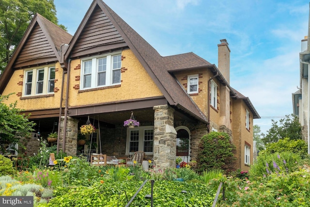 627 E Allens Ln, Philadelphia, PA 19119 - rear view of property featuring a chimney, stone siding, a porch, and a shingled roof