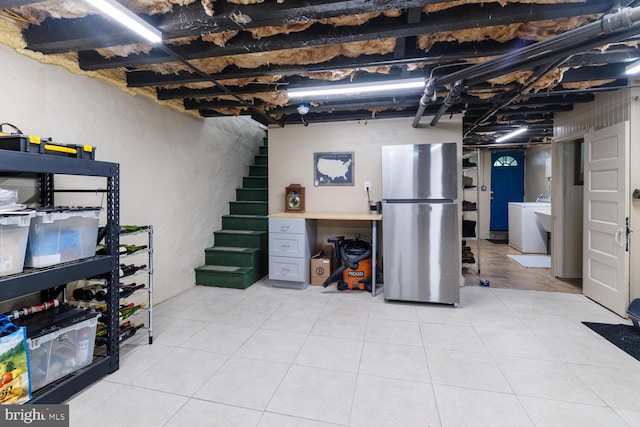 627 E Allens Ln, Philadelphia, PA 19119 - basement with freestanding refrigerator, washer / dryer, stairway, and light tile patterned flooring