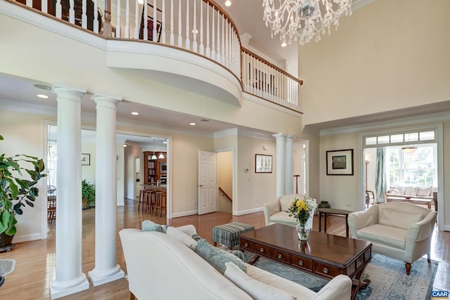 455 Foxdale Ln, Charlottesville, VA 22903 - living room featuring a towering ceiling, decorative columns, crown molding, wood finished floors, and recessed lighting