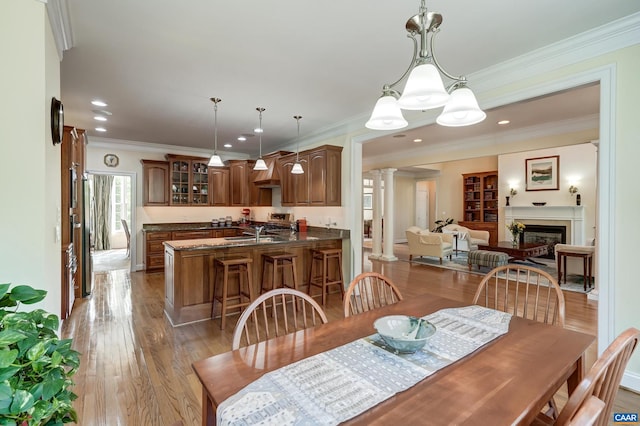 455 Foxdale Ln, Charlottesville, VA 22903 - dining room with ornate columns, wood finished floors, ornamental molding, a glass covered fireplace, and recessed lighting