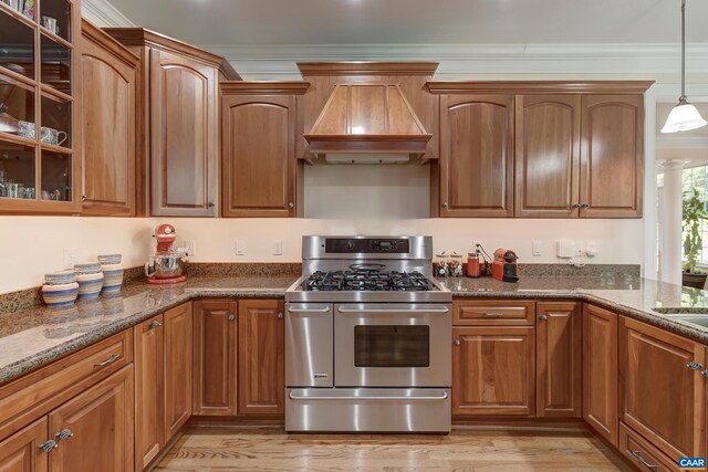 455 Foxdale Ln, Charlottesville, VA 22903 - kitchen with stainless steel gas range oven, custom exhaust hood, glass insert cabinets, hanging light fixtures, and light wood-style flooring