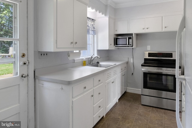 509 Baynard Blvd, Wilmington, DE 19803 - kitchen with stainless steel appliances, white cabinets, light countertops, and ornamental molding