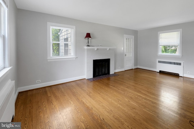 509 Baynard Blvd, Wilmington, DE 19803 - unfurnished living room featuring radiator, a fireplace, healthy amount of natural light, and wood finished floors