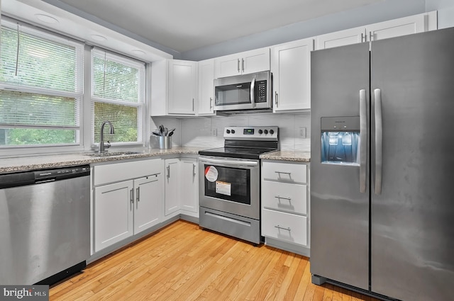 9355 Pan Ridge Rd Unit 9355, Parkville, MD 21234 - kitchen with stainless steel appliances, light wood-type flooring, white cabinets, and light stone counters