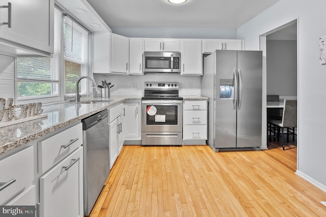 9355 Pan Ridge Rd Unit 9355, Parkville, MD 21234 - kitchen featuring stainless steel appliances, light wood finished floors, and white cabinetry