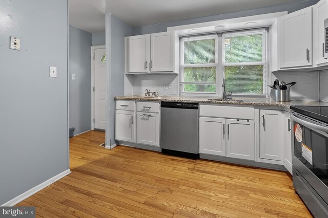 9355 Pan Ridge Rd Unit 9355, Parkville, MD 21234 - kitchen with stainless steel appliances, white cabinets, light wood-type flooring, and backsplash