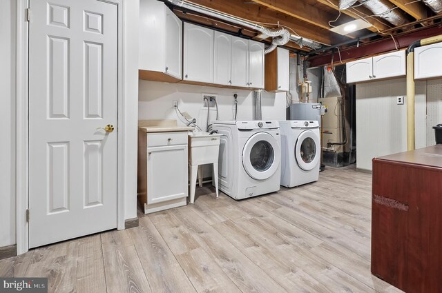9355 Pan Ridge Rd Unit 9355, Parkville, MD 21234 - laundry area featuring independent washer and dryer, cabinet space, and light wood-type flooring