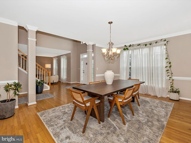14228 Golden Hook Rd, Boyds, MD 20841 - dining room featuring a chandelier, ornate columns, light wood-style flooring, crown molding, and stairs