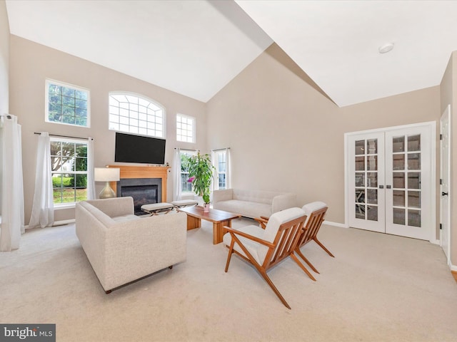 14228 Golden Hook Rd, Boyds, MD 20841 - living room with high vaulted ceiling, a glass covered fireplace, french doors, healthy amount of natural light, and light carpet