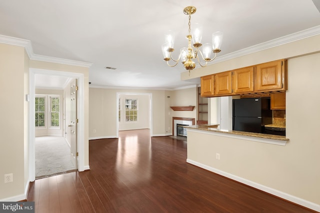 11021 Folksie Ct Unit 201, Manassas, VA 20109 - kitchen featuring freestanding refrigerator, a chandelier, dark wood-style flooring, crown molding, and a glass covered fireplace
