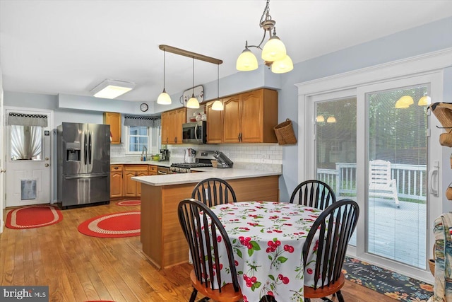 69 Cardinal Forest Dr, Fredericksburg, VA 22406 - kitchen featuring appliances with stainless steel finishes, light wood-style floors, light countertops, a peninsula, and brown cabinetry