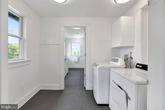 1329 Delafield Pl NW, Washington, DC 20011 - laundry room with washing machine and dryer, healthy amount of natural light, dark tile patterned flooring, and cabinet space