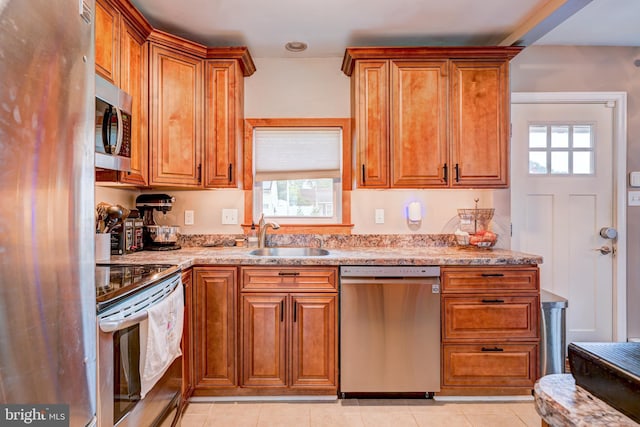 67 Neptune Ln, Levittown, PA 19054 - kitchen with appliances with stainless steel finishes, brown cabinets, light tile patterned flooring, and light stone countertops
